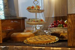 una mesa con pan y un pastel en una mesa con frutas en Agriturismo L'Ulivo in Fiore, en Spoleto