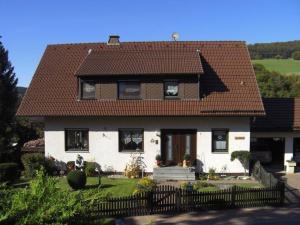 une maison blanche avec un toit marron dans l'établissement Ferienwohnung Fischer, à Heringhausen