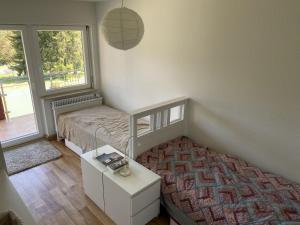 a bedroom with a bed and a table and a window at Haus Gutach in Schönwald