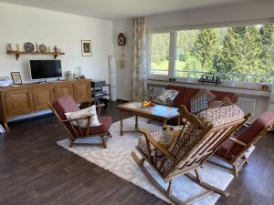 sala de estar con sofá, sillas y mesa en Haus Gutach en Schönwald