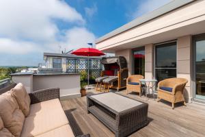 eine Terrasse mit Gartenmöbeln und einem Grill auf einem Haus in der Unterkunft Villa Deichgraf in Börgerende-Rethwisch