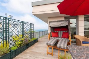 einen Balkon mit einem Bett, einem Tisch und einem Sonnenschirm in der Unterkunft Villa Deichgraf in Börgerende-Rethwisch