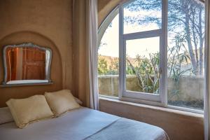 a bedroom with a bed and an open window at Casa Los Arcos at Masia Nur Sitges, Adults only in Canyelles