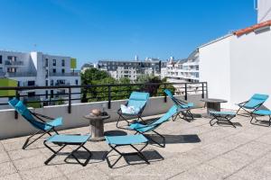 un groupe de chaises et une table sur un toit dans l'établissement Résidence New Rochelle, à La Rochelle