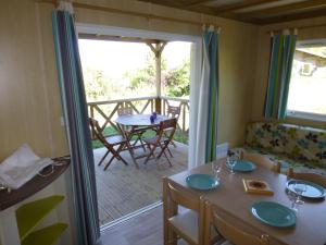 a dining room with a table and a balcony at Camping Les Terrasses de Dordogne in Rouffignac Saint-Cernin