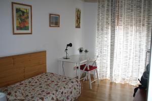 1 dormitorio con cama, mesa y escritorio en Casa Nipitella, en Catania