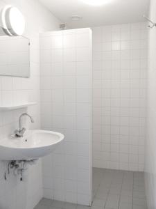 a white bathroom with a sink and a mirror at Vakantiepark Broedershoek in Koudekerke +18 photos