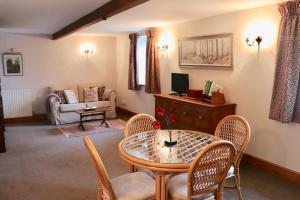 a living room with a table and chairs at Old Camms Holiday Cottages in Askrigg