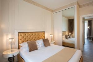 a bedroom with a large bed and a mirror at Suite Milano Duomo in Milan