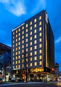 ein hohes schwarzes Gebäude mit Licht an in der Unterkunft Daiwa Roynet Hotel Sendai Ichibancho PREMIER in Sendai