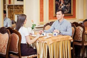a man and a woman sitting at a table at Hotel Versailles in Lutsk