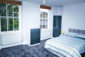 1 dormitorio con 1 cama y 2 ventanas en Camden Guest House Super king or Double Bedroom, en Londres