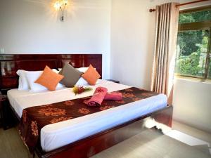 a bedroom with a bed with two pink towels on it at Vista D'Oro in Praslin