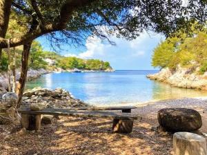 a bench sitting on the shore of a lake at Villa Stone House Poplat in Vela Luka