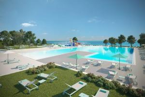 una vista aérea de una piscina con sillas y sombrillas en Camping Adria Mobile Home Park Umag, en Umag