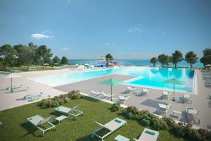 an overhead view of a swimming pool with chairs and umbrellas at Camping Adria Mobile Home Park Umag in Umag