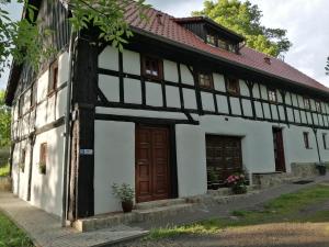een oud wit gebouw met bruine deuren bij Rębiszów 50 in Rebiszów