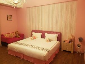 a bedroom with a bed with two teddy bears on it at Baby Pig B&B in Taitung City