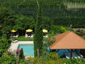 einen Blick über einen Pool mit Sonnenschirmen in der Unterkunft Hotel FleurAlp in Tscherms