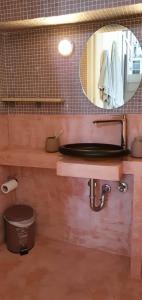 La salle de bains est pourvue d'un lavabo et d'un miroir. dans l'établissement Beautiful Dollhouse in Hydra, à Hydra
