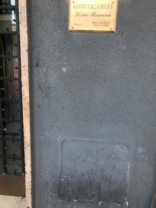 un cartello sul lato di un muro con una presa d'aria di Affittacamere Romina a Bologna
