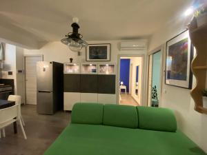 a living room with a green couch and a refrigerator at Mood's Home in Avola