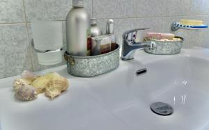 a bathroom counter with a sink with a basket of cleaning products at Casa Vacanza Nonna Nena in Porto Empedocle