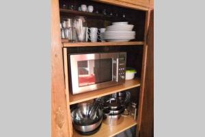 a microwave on a shelf in a kitchen at Stadtferienwohnung Lüneburg in Lüneburg