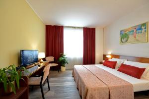 una camera d'albergo con letto, scrivania e TV di Hotel Krystal a Bussolengo