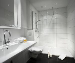 a white bathroom with a toilet and a shower at Hotel zum Rössel in Kandel