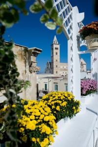 a white balcony with yellow flowers and a building at White House in Trani