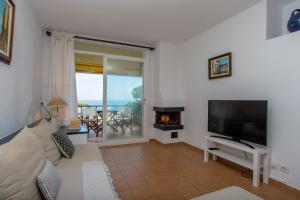 a living room with a couch and a tv and a fireplace at C-5 CALELLA DE PALAFRUGELL 5 PAX in Calella de Palafrugell