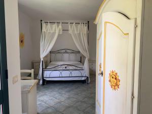 a bedroom with a white bed with a canopy at Hotel La Ciaccia in Valledoria +63 photos