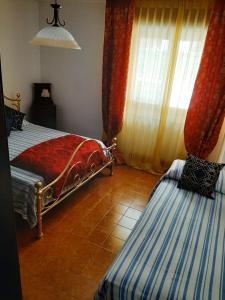 a bedroom with two beds and a window with curtains at La Beccaccia in Baceno