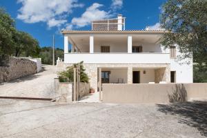 een wit huis met een hek ervoor bij Relax e Belvedere in Fasano