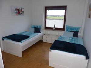 um quarto com 2 camas e uma janela em Ferienwohnung Lorenzen em Husum