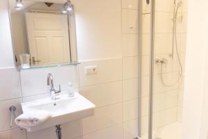 a bathroom with a sink and a shower at Ferienwohnungen Zur Tenne in Beckingen +30 photos