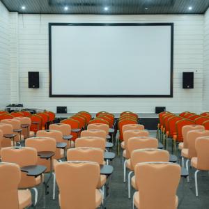 an empty lecture hall with chairs and a screen at RIVER INN RESORT AND SPA in Nabran +150 photos