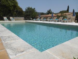een groot zwembad met stoelen en een huis bij La Bergerie in Saint-Maximin-la-Sainte-Baume