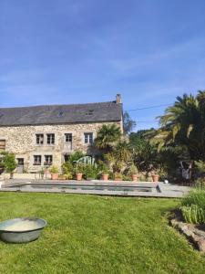 a stone house with a garden in front of it at La petite Hautière Maison 2 personnes Plouer sur Rance avec piscine in Plouër-sur-Rance