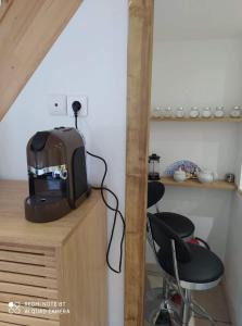 a kitchen with a toaster and two chairs on a counter at La petite Hautière Maison 2 personnes Plouer sur Rance avec piscine in Plouër-sur-Rance