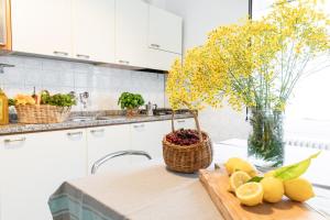 a kitchen with a table with fruit and a vase of flowers at Marina in San Bartolomeo al Mare