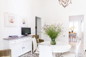 a white living room with a table with a vase of flowers at Marina in San Bartolomeo al Mare