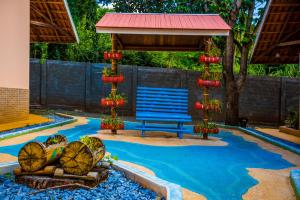 un banco azul sentado bajo un pabellón en un patio en Ody Park Resort Hotel, en Iguaraçu