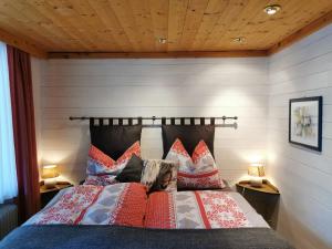 a bedroom with a bed with red pillows at Apartments Helsen in Mühlbach am Hochkönig