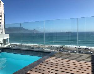 a view of the beach from the balcony of a building at Infinity Self Catering Apartments in Bloubergstrand