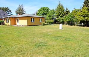 une petite maison jaune dans une cour herbeuse dans l'établissement Ferienhaus Sabine mit Kamin und So, à Baabe