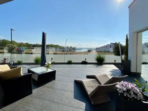 佩內明德的住宿－Exklusive Ferienwohnung mit Blick auf den Yachthafen，天井配有两张沙发、一张桌子和鲜花