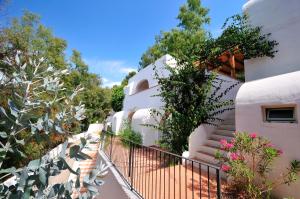 a white house with stairs and plants on it at Arbatax Park Resort - Ville del Parco in Àrbatax