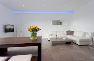 ein Wohnzimmer mit einer weißen Couch und einem Tisch in der Unterkunft Exklusive Ferienwohnung mit Blick auf den Yachthafen in Peenemünde + 2 Fotos